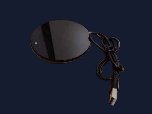 Chauffe-tasse USB noir compact avec son câble d'alimentation, vue de dessus sur fond bleu nuit, accessoire Burosophe pour garder le café chaud.