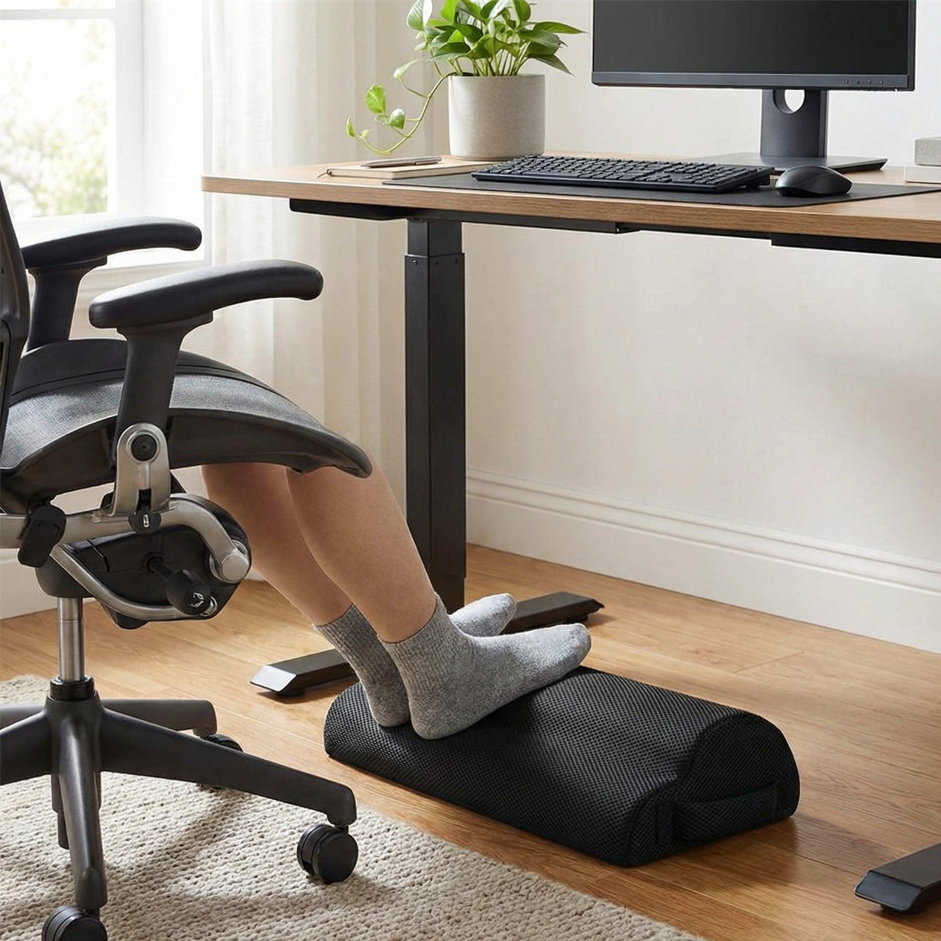Repose-pieds ergonomique de bureau en mousse à mémoire de forme, améliorant la posture et le confort des pieds en chaussettes sous un bureau moderne.